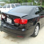 Before and after photographs of a damaged black Volkswagon Jetta that was repaired by Elite Paint & Body Shop in West Palm Beach, Florida.